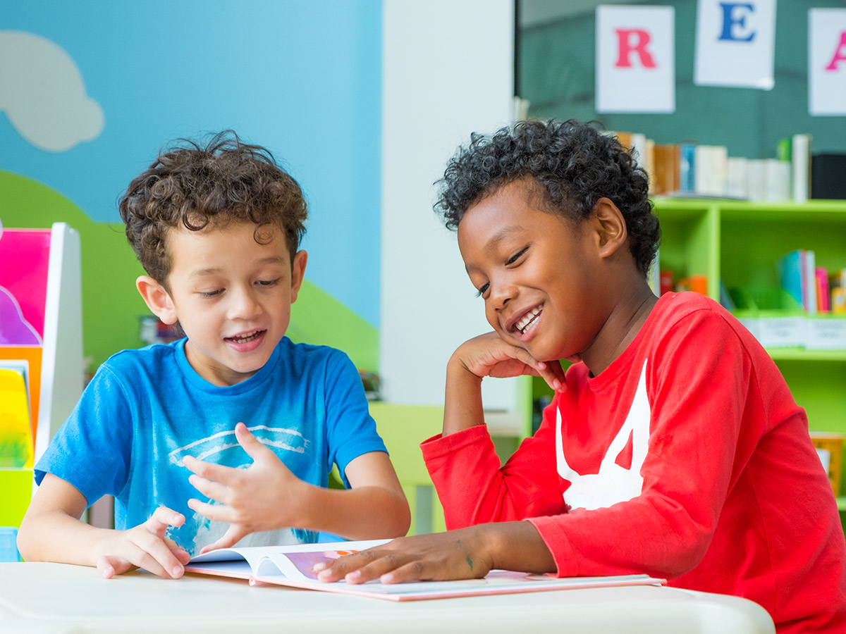 Two boys reading a book together