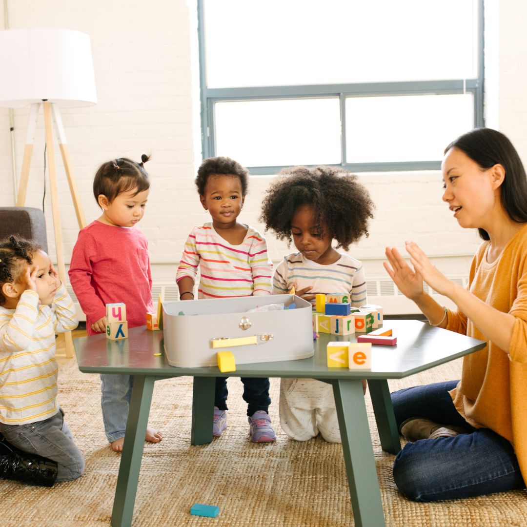 Daycare teacher with kids at a table